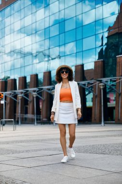 A woman in white walks through a European city, radiating confidence and style. clipart