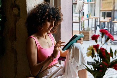 Tablet içeriğine batırılmış şık bir kadın otururken.