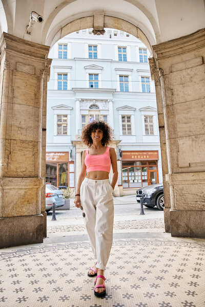 Стильная женщина позирует в европейском городе, демонстрируя свою повседневную, но модную одежду.