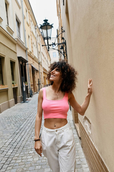 Стильная женщина идет по европейскому переулку, исследуя город.