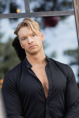 Yakışıklı, siyah gömlekli sarışın bir adam Orlando, Florida 'da sokakta duruyor..