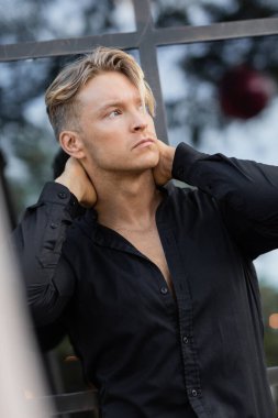 Siyah tişörtlü yakışıklı sarışın adam Orlando, Florida 'da bir şehir caddesinde duruyor..