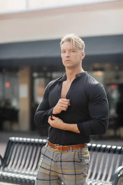 Stock image A handsome blonde man in stylish attire stands on a street in Orlando, Florida.