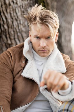 Miami 'de kahverengi süet ceketli sarışın bir adam oturuyor..