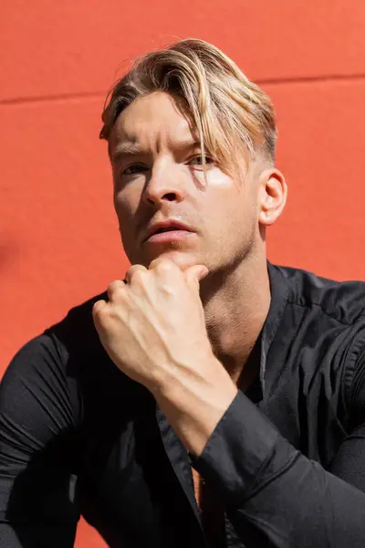 stock image A handsome blonde man in stylish attire poses on a street