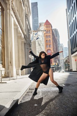 Woman dances gracefully in NYC streets, showcasing her talent amidst urban backdrop. clipart