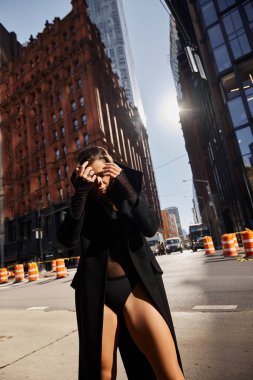 Genç bir kadın güneşli bir günün altın ışığında New York sokaklarında özgürce dans ediyor..