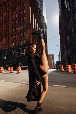Siyah ceketli genç bir kadın New York sokaklarında dans ediyor..