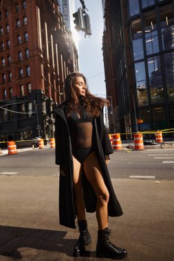 A young woman in a black outfit dances on a New York street. clipart