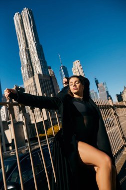 Genç bir kadın New York City gökdelenlerinin arka planında dans ediyor..