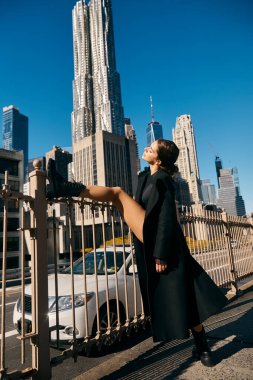 A woman dances on a bridge in New York City. clipart