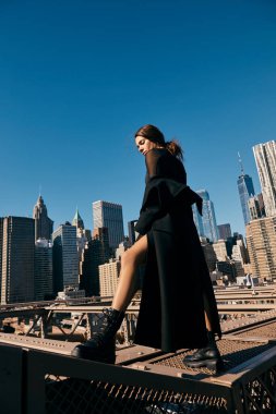 Genç bir kadın New York 'ta bir köprüde dans ediyor. Etrafı gökdelenlerle çevrili..