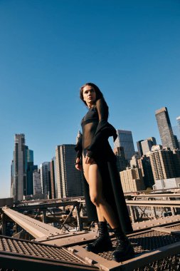 A young woman dances on a bridge in New York City. clipart