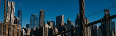 Bir köprünün kablolarından çekilen Manhattan siluetinin görüntüsü..