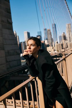 Brooklyn Köprüsü 'nde dikilen genç bir kadın şehrin ufuk çizgisine bakıyor..