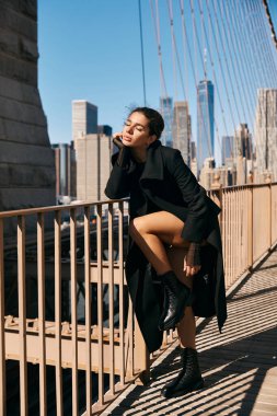 Şehre tepeden bakan bir köprüde dans eden genç bir kadın. Hareketleri zarif ve özgür..