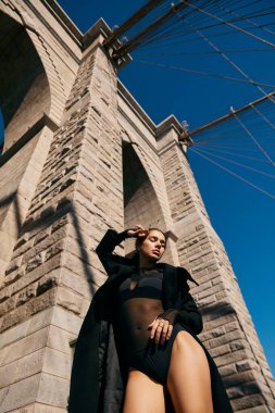 New York 'taki Brooklyn Köprüsü' nün altında genç bir kadın dans ediyor..