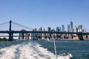 East River 'daki bir tekneden Brooklyn Köprüsü de dahil New York şehrinin ufuk çizgisi manzarası..