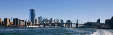 A view of the Brooklyn Bridge and the New York City skyline from the East River. clipart
