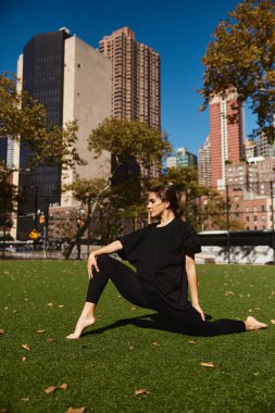 Genç bir kadın New York City parkında dans pozu veriyor..