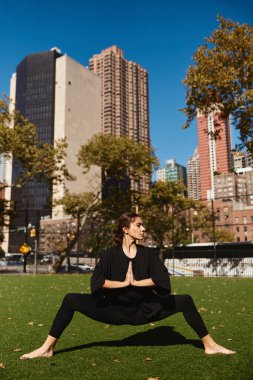 Genç bir kadın New York 'ta bir parkta yoga yapıyor..
