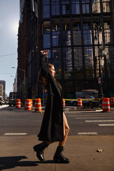 Молодая женщина танцует на улицах Нью-Йорка.