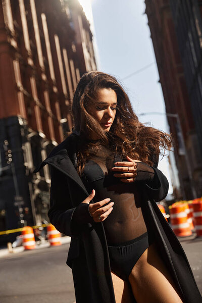 Silhouetted against NYC buildings, a young woman dances in the street.