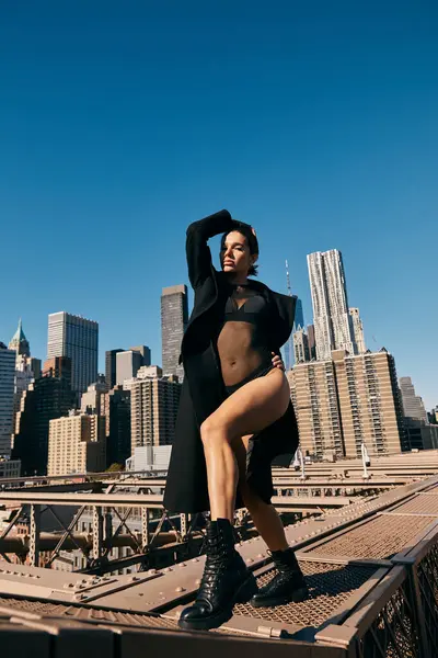 stock image A young woman dances on the Brooklyn Bridge in New York City, wearing a black outfit.