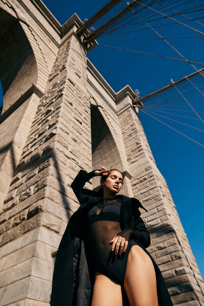 A young woman dances beneath the iconic Brooklyn Bridge in New York City.