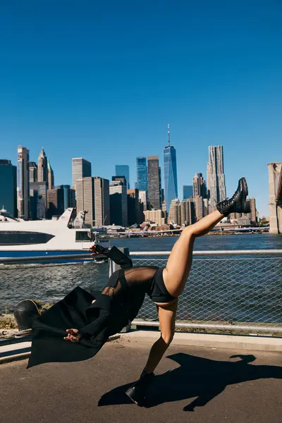 stock image A young woman dances in NYC, silhouetted by skyline.