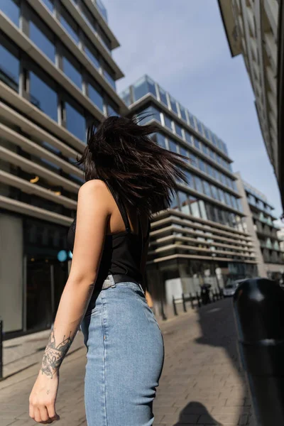 Visão traseira da mulher tatuada em pé na rua urbana turva em Praga — Fotografia de Stock
