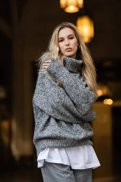 Young blonde woman in grey sweater standing with crossed arms in New York — Stock Photo