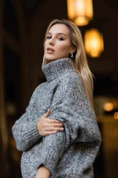 Retrato de mujer joven en suéter gris mirando a la cámara en Nueva York - foto de stock