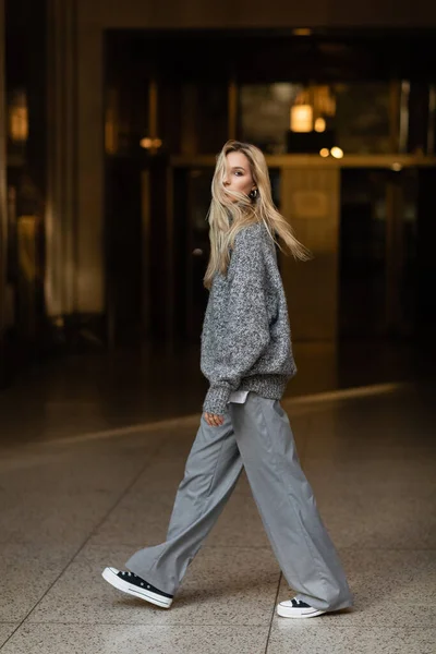 Comprimento total de mulher jovem e elegante em roupa cinza andando na rua de Nova York — Fotografia de Stock