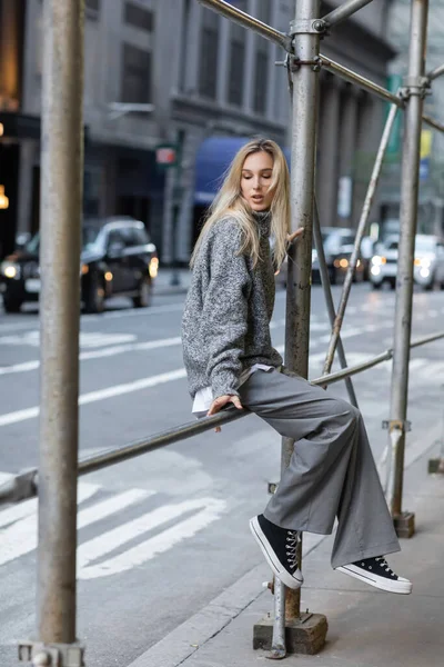 Полная длина стильная женщина в сером зимнем наряде позирует на городской улице в Нью-Йорке — стоковое фото
