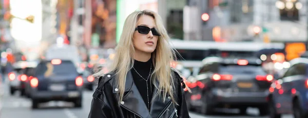 Стильная молодая женщина в кожаной куртке и солнцезащитных очках позирует на улице Нью-Йорка, баннер — стоковое фото