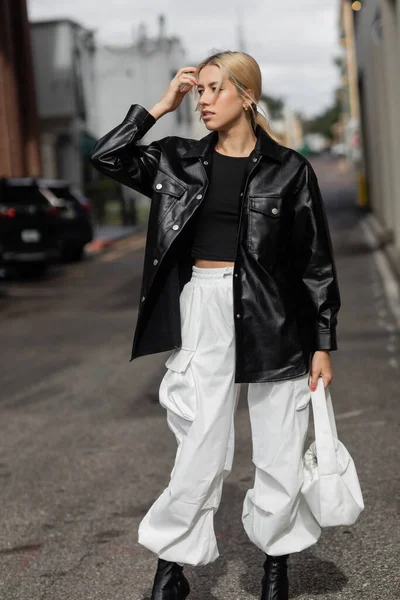 Молода блондинка в стильному одязі з сумочкою на вулиці в Маямі. — стокове фото