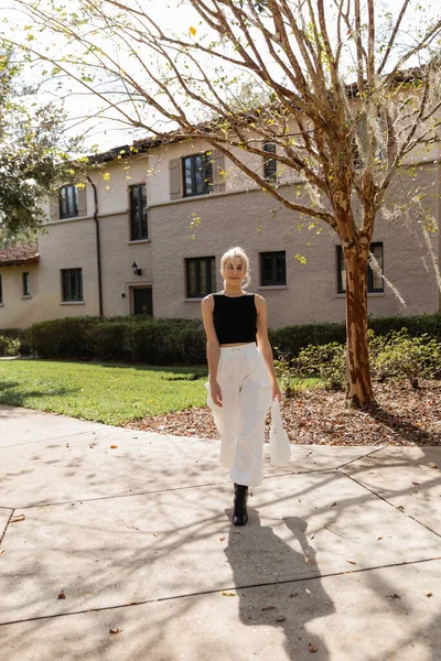 Довга блондинка з сумочкою, що стоїть біля будинку в Маямі. — Stock Photo