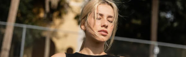 Jeune femme blonde avec les yeux fermés debout à l'extérieur, bannière — Photo de stock