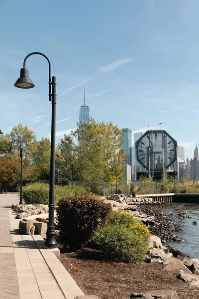 Embankment with lanterns and plants with cityscape of New York City — Fotografia de Stock