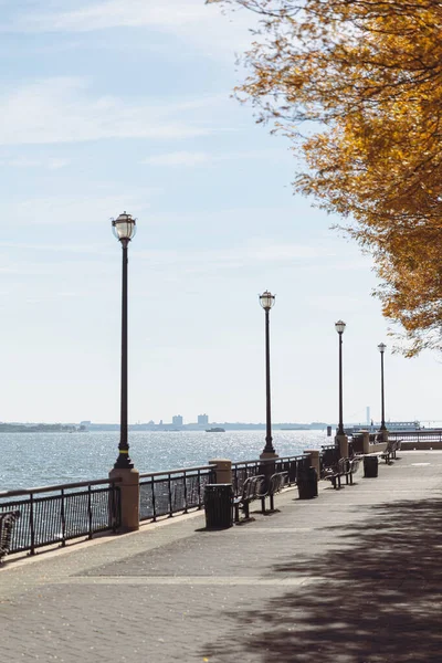 Embankment with lanterns and walkway near river bay in New York City — Foto stock