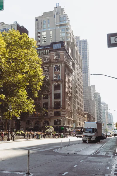 NUEVA YORK, EE.UU. - 13 de octubre de 2022: árbol con follaje otoñal cerca de edificios y peatones en la calle de la ciudad - foto de stock