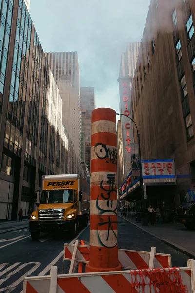 НЬЮ-ЙОРК, США - 13 ОКТЯБРЯ 2022 года: дорожный знак и грузовик возле радио городского мюзик-холла в центре города — стоковое фото