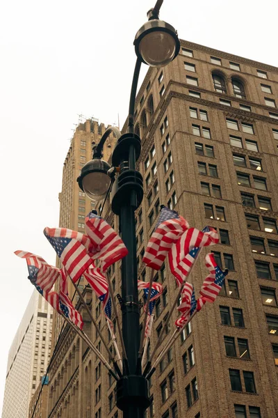 Low angle view of usa flags on street lantern in New York City — Photo de stock