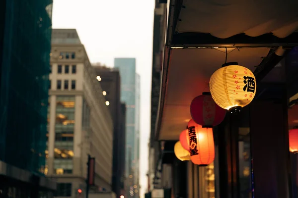 Luminous lanterns with hieroglyphs in Chinese district on blurred background in New York City — стокове фото