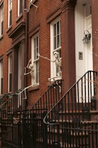 Casa con esqueletos de Halloween en ventanas blancas en el distrito de Brooklyn Height de la ciudad de Nueva York - foto de stock
