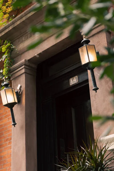 Casa de pedra com porta preta e lanternas em primeiro plano borrado em Nova York — Fotografia de Stock