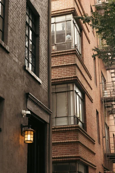 Edificios de piedra con balcones acristalados y linterna en la calle de la ciudad de Nueva York - foto de stock
