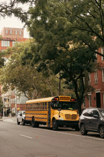NOVA IORQUE, EUA - OUTUBRO 13, 2022: ônibus escolar amarelo sob árvores de rua urbana no distrito de Brooklyn Altura — Fotografia de Stock