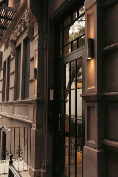 Серое здание со светильниками возле стеклянной двери в районе Бруклин Хайтс в Нью-Йорке — стоковое фото